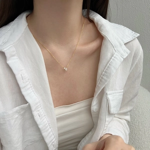 Close-up of minimalist golden S925 silver necklace with pear-shaped zircon on a model
