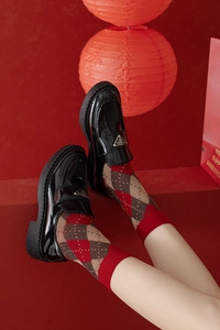 Gros plan de chaussettes en laine à motifs flocon et losanges avec des mocassins en cuir