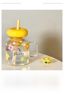 Detail of floral glass tumbler with yellow lid, matching straw and flower dust cap
