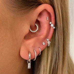 Macro shot of S925 silver earring set featuring zircon studs and heart shaped ear cuffs