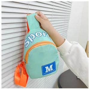 Détail du sac bandoulière enfant en nylon vert menthe et orange avec imprimé sport