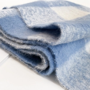 Close-up of soft mohair texture and blue and white checkered pattern on a fluffy scarf