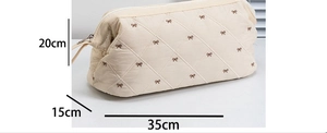 Quilted beige hair dryer storage bag with bow embroidery and size dimensions 35x15x20cm