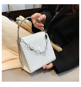 Detail of white textured handbag with silver metal handle and elegant chain strap