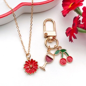 Detail of gold flower pendant necklace with red wine glass and cherry alloy charms