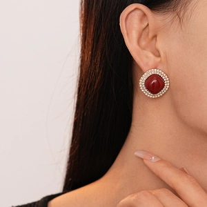 Gros plan de boucles d'oreilles vintage avec pierre carrée rouge et cristaux dorés