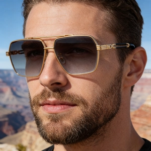 Close-up of men's aviator sunglasses with gold metal frame and gradient lenses