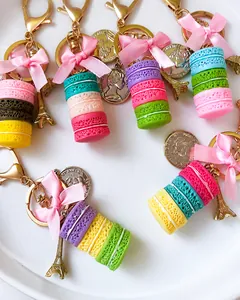 Nahaufnahme von bunten Macaron-Schlüsselanhängern mit rosa Schleifen und Eiffelturm.