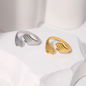 Detailed close-up of hugging hand rings in gold and silver finish on stone pedestals