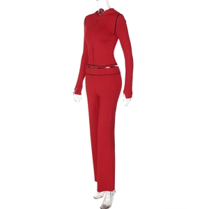 Detailed studio shot of a red hooded cardigan and slim-fit trousers with dark stitching