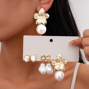 Detail of vintage gold flower and pearl earrings set in French retro aesthetic style