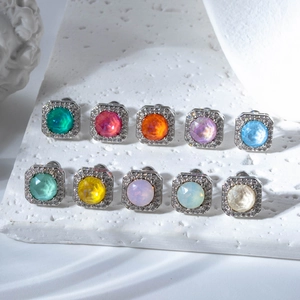 Colorful sugar-cube stud earrings in macaron tones with crystal halo on stone display