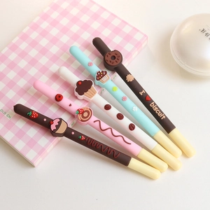 Five assorted dessert-themed silicone pens featuring 3D donuts and cupcakes on a notebook