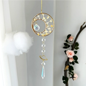 Detail of sun catcher with golden crescent moon, yellow crystals and iridescent prism