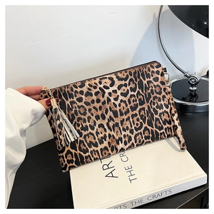 Detailed macro view of leopard print clutch bag texture with a stylish tassel zipper pull