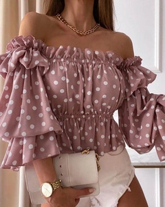 Details der rosa schulterfreien Polka-Dot-Bluse mit Rüschenärmeln und Gummizug