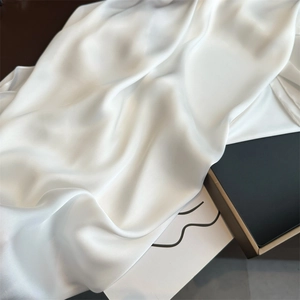 Close-up of white satin silk scarf with soft light highlighting the smooth texture