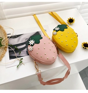 Detailed close-up of pink and yellow strawberry-shaped crossbody bags with floral accents