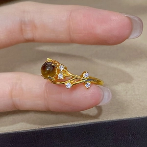 Detailed macro view of the gold plated tiger eye ring with zircon stones on finger