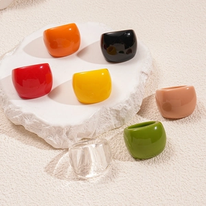 Close-up of colorful chunky resin square rings in vibrant shades on a textured stone plate