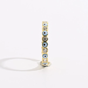 Detail of gold evil eye eternity band ring with blue enamel and sparkling cubic zirconia