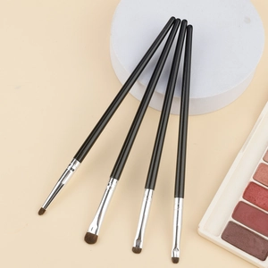Dettaglio del set di 4 pennelli per occhi professionali con manici neri su sfondo beige