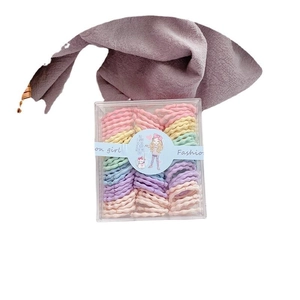 Colorful candy-colored mini elastic hair ties for girls in a clear storage box