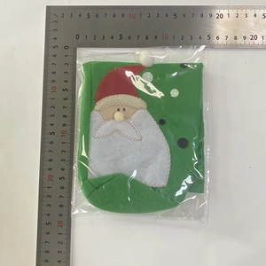 Détail d'un sac cadeau de Noël pour bouteille de vin en feutre vert avec motif Père Noël
