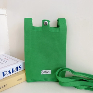 Detailed close-up of green knitted phone bag with silver snap and Stannum label