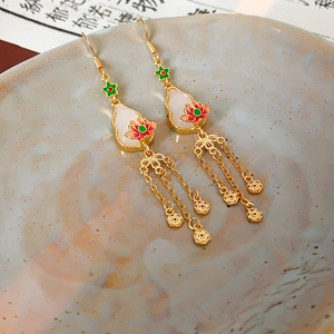 Detail of gold gourd earrings with enamel lotus and delicate triple metal tassels