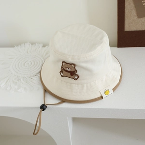 Close-up of baby sun hat with cute bear embroidery and adjustable brown drawstring