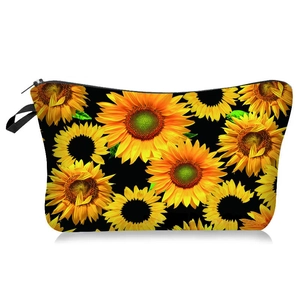 Détail de la trousse à maquillage avec motif tournesol, fermeture éclair et dragonne
