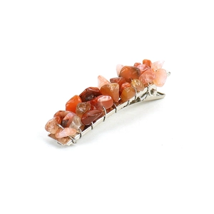 Macro view of handmade hair clip with orange natural crushed stones and wire wrapping