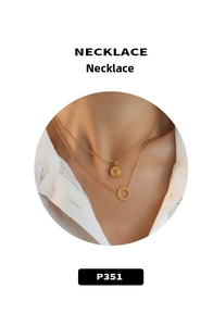 Dettaglio della collana a doppio strato in oro 18 carati con pendenti a moneta e sole