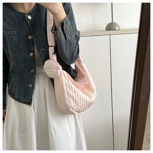 Detailed shot of pink quilted crossbody bag with matching round coin purse on shoulder