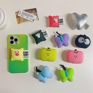 Detailed flat lay of cute plush phone sockets in various shapes on a creamy background