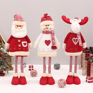 Detailed view of Christmas plush dolls featuring red knitted long legs on festive decor