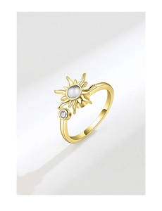Macro detail of sunburst golden ring with translucent stone and zircon accent