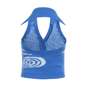 Dettaglio del gilet in maglia blu a lupetto con motivo a vortice bianco e texture