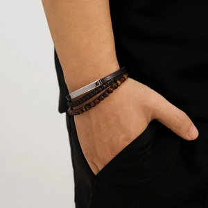 Detail of multi-layer men's bracelet with brown leather, braid, and tiger eye beads