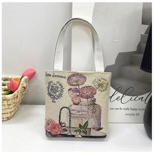 Detail of beige canvas tote with floral embroidery and Jardinier text in a lifestyle set