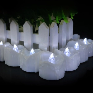 Cold white LED tea light candles arranged by white fence background for holiday decor