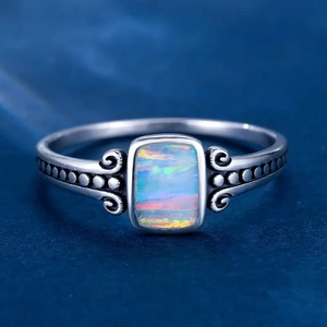 Macro detail of rectangle opal ring featuring vintage scrollwork and silver band