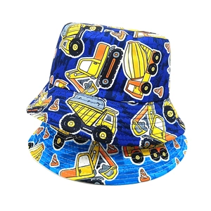Detailed stack of navy and blue reversible kids bucket hats with cartoon truck patterns