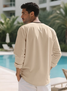 Rear view of men's beige linen Henley shirt at a resort pool, showing loose casual fit