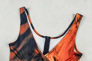 Detailed close-up of tiger print jumpsuit neckline with black zipper and orange stripes