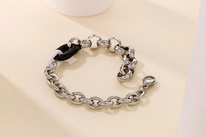 Gros plan détaillé du bracelet chaîne argenté avec maillon en résine noir et blanc