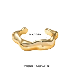 Detail view of a 6cm golden irregular wave textured open bangle with weight specs
