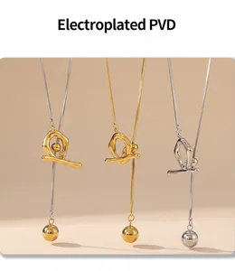 Detailed view of PVD electroplated stainless steel necklaces with orb pendants on books