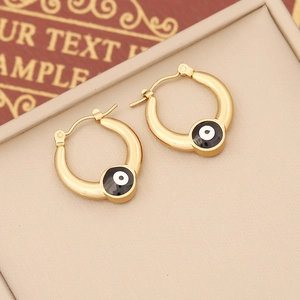 Golden stainless steel evil eye hoop earrings with enamel inlay on a beige tray